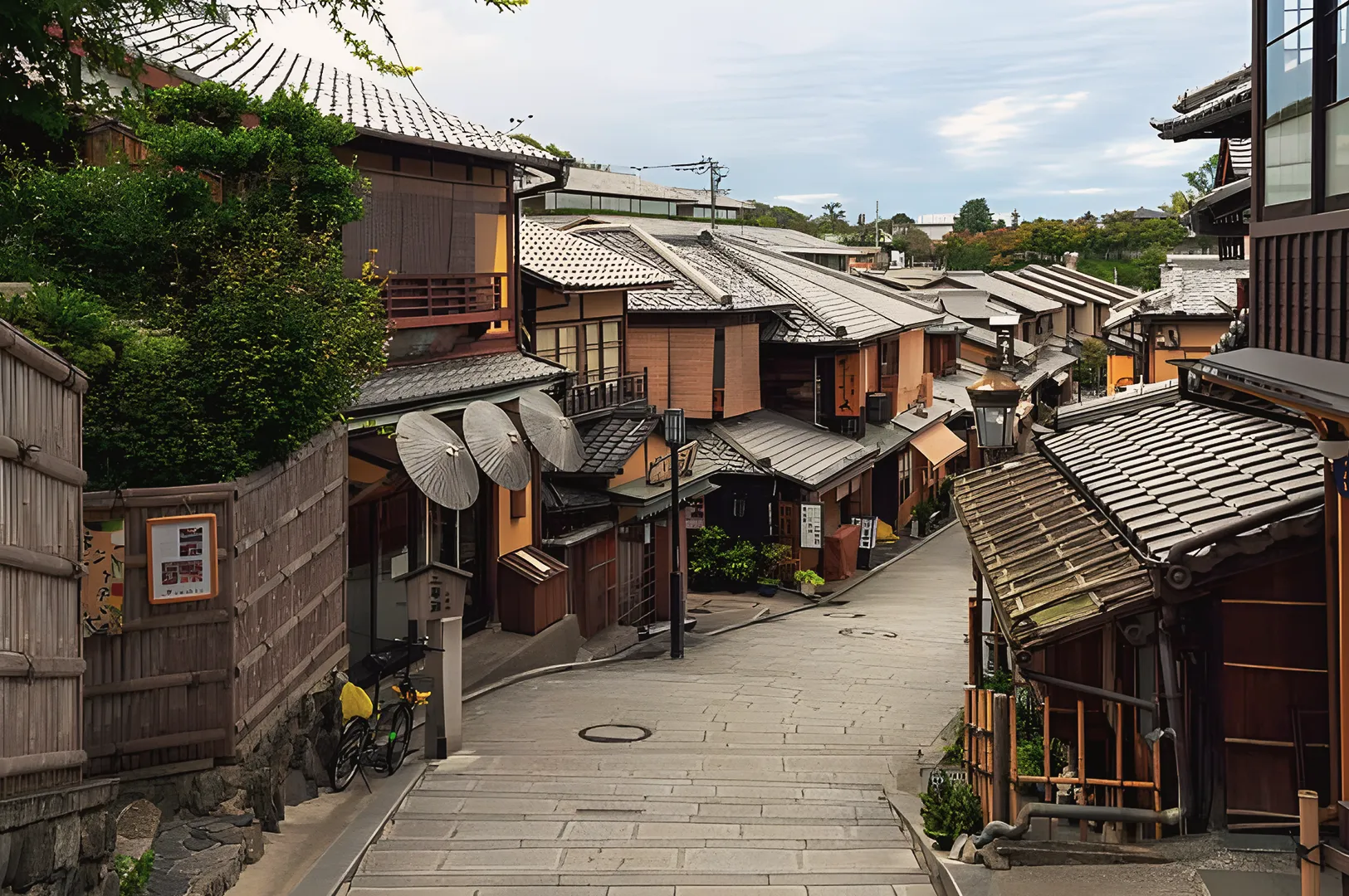 Peaceful narrow street in Kyoto lined with traditional wooden houses and tiled roofs, showcasing classic Japanese architecture and cultural charm.