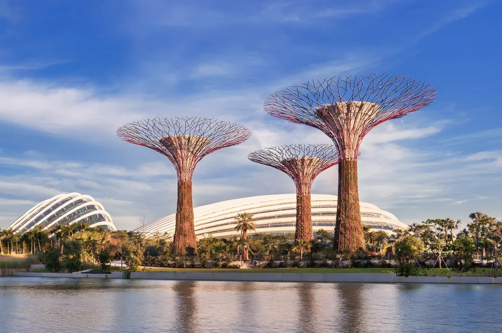 Supertree Grove at Gardens by the Bay, Singapore — futuristic vertical gardens and glass conservatories under a bright blue sky, symbolizing sustainable urban design.