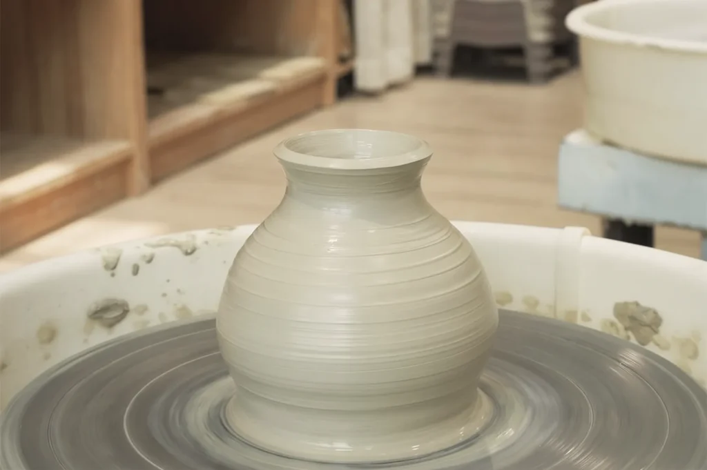 Freshly shaped clay vase spinning on pottery wheel at Taoz Ceramics Studio — hands‑on pottery making experience in Singapore.